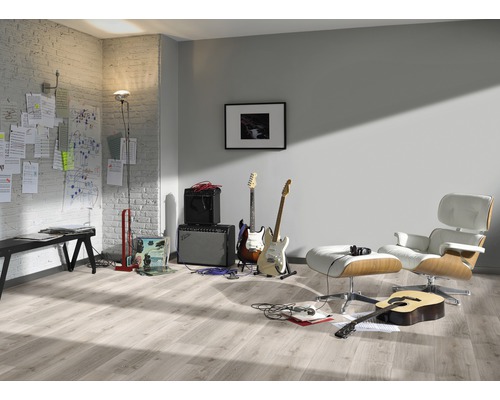 Pièce lumineuse avec des guitares, des amplificateurs, un fauteuil et un sol stratifié