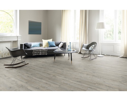 Salon lumineux avec sol stratifié, canapé et chaises