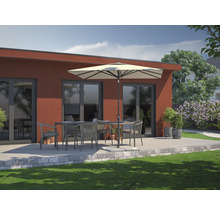 Scène de terrasse avec mobilier de jardin, parasol et verdure devant un bâtiment