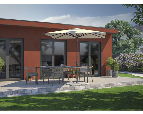 Scène de terrasse avec mobilier de jardin, parasol et verdure devant un bâtiment