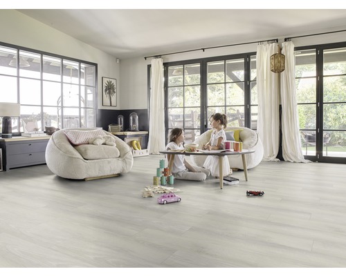 Heller Raum mit Vinylboden, Sesseln und spielenden Kindern.