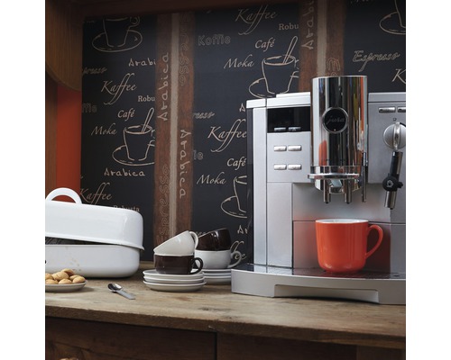 Scène avec une machine à café entièrement automatique Jura, des tasses et des pâtisseries sur une table en bois