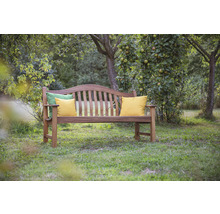 Banc de jardin en bois avec coussins sur une pelouse