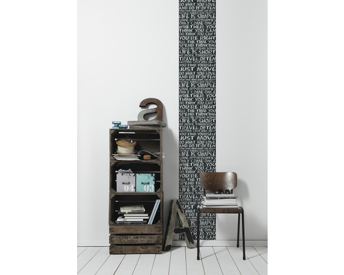 Aménagement de pièce avec étagère en caisses en bois, éléments de décoration et papier peint mural avec motifs d''écriture