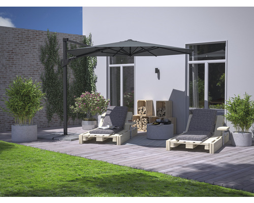 Gartenszene mit zwei Holzliegen, Sonnenschirm, Holzkisten, Pflanzen und Rasen