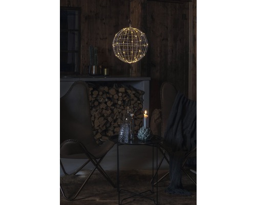 Ambiance de vie décorative avec une boule en fil métallique et des lumières LED, complétée par des fauteuils et une table d''appoint.
