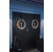 Porte d''entrée décorée avec des couronnes et des bacs à plantes