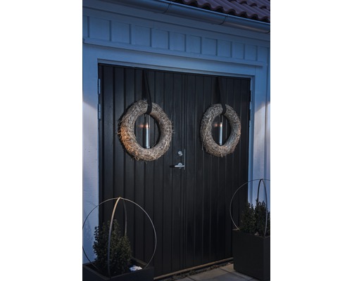 Porte d''entrée décorée avec des couronnes et des bacs à plantes