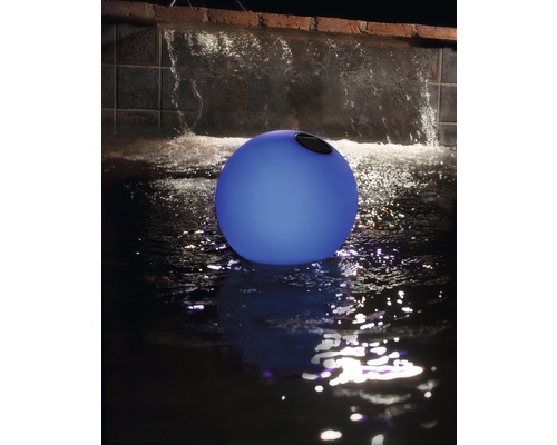 Dekorative Kugel für den Garten im Wasser mit Wasserfall im Hintergrund