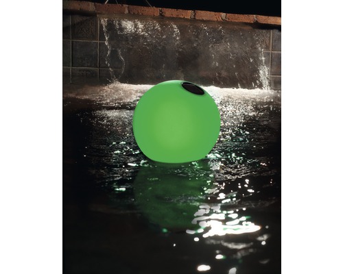 Grüne Schwimmleuchte im Wasser vor einem Wasserfall