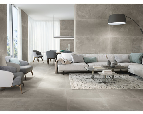 Salon lumineux avec carrelage gris, canapé, fauteuils et table à manger