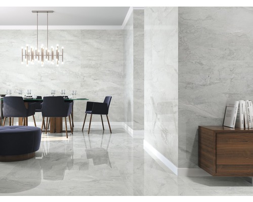 Heller Raum mit Esstisch und Wand- sowie Bodenfliesen in Marmoroptik