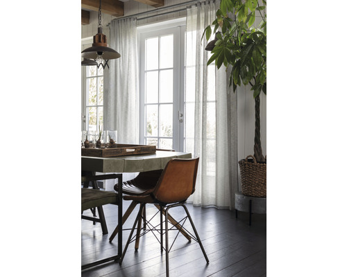Salle à manger lumineuse avec table à manger, chaises, rideaux et plante d''intérieur