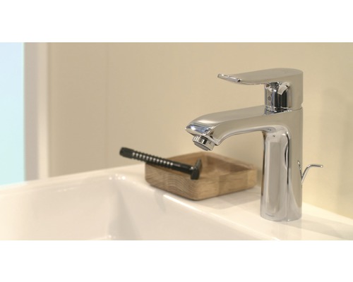 Chromfarbene Waschtischarmatur auf einem Waschbecken mit einem Rasierhobel