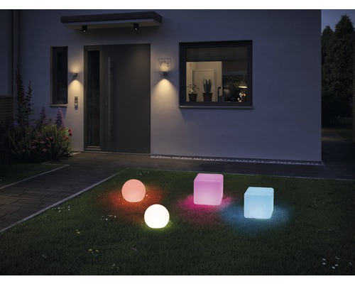 Jardin éclairé avec des luminaires d''extérieur colorés en forme de cube et de sphère