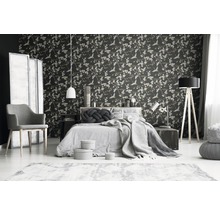 Schlafzimmer mit floraler Tapete, Bett, Stuhl und Lampen