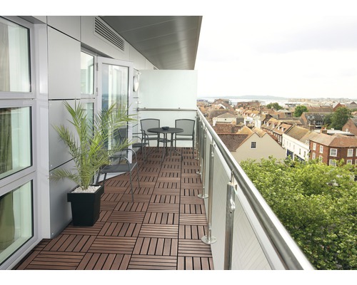 Aménagement d''un balcon avec des dalles de terrasse, une table et des chaises