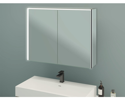 Armoire de toilette éclairée au-dessus d''un lavabo dans une salle de bains.