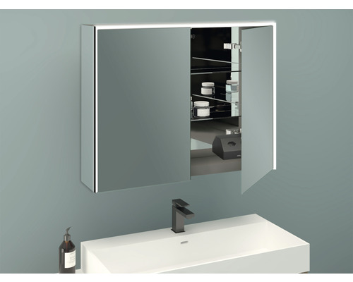 Armoire de toilette éclairée au-dessus d''un lavabo dans une salle de bains