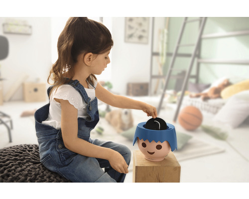 Fille jouant avec une tirelire dans une chambre d''enfant