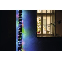 Photo extérieure d'un mur de maison avec une guirlande lumineuse LED fixée à côté d'une fenêtre.
