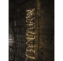 Guirlande lumineuse décorative sur une grille métallique contre un mur de briques