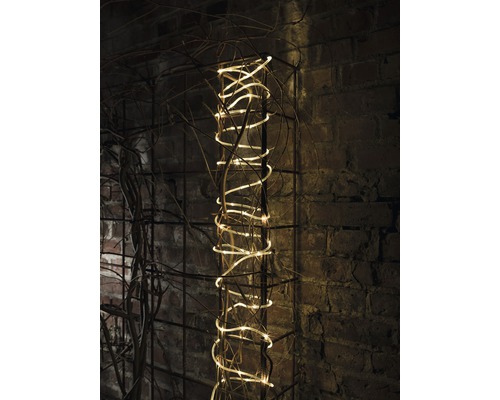 Guirlande lumineuse décorative sur une grille métallique contre un mur de briques