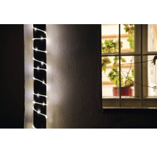 Guirlande lumineuse décorative enroulée autour d''un poteau, plante d''intérieur visible à la fenêtre.