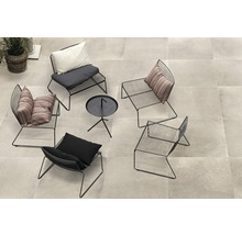 Eine Loungeecke mit vier Metallstühlen und einem kleinen Tisch auf Terrassenplatten