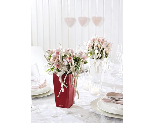 Dekorierter Tisch mit rotem Pflanzgefäß mit Blumenarrangement