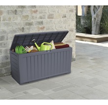 Geöffnete Gartenbox mit Gartengeräten und Sitzkissen vor einer Mauer