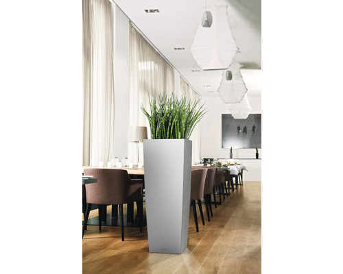 Haut bac à fleurs carré avec plante verte dans une pièce lumineuse