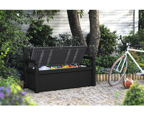 Coffre de jardin ouvert avec des jouets, un ballon et un vélo en arrière-plan