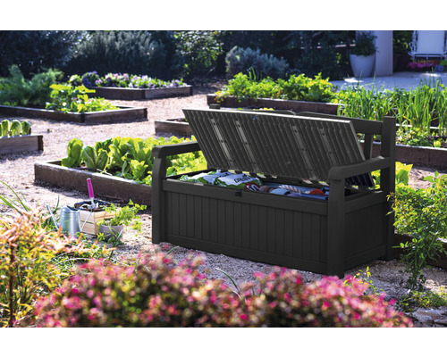 Coffre de banc de jardin ouvert dans le jardin avec outils de jardinage.