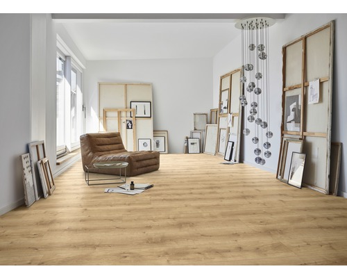 Pièce lumineuse avec sol stratifié, fauteuil et œuvres d'art.