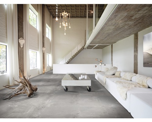 Heller Wohnraum mit Betonboden, Sofa, Tisch und Treppe