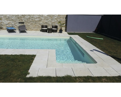 Swimmingpool mit Steinumrandung und Gartenmöbeln