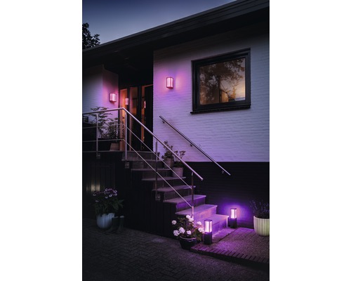 Façade de maison avec luminaires extérieurs éclairés sur le mur et les escaliers