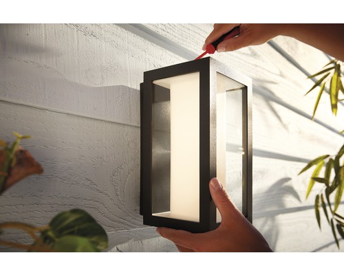 Installation d''un luminaire extérieur rectangulaire sur un mur de maison