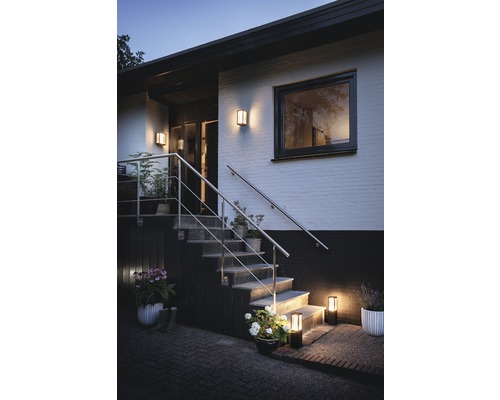 Extérieur d''une maison avec escalier et éclairage extérieur créant une ambiance accueillante.