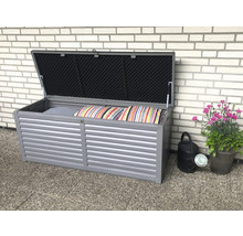 Geöffnete graue Gartenbox mit Kissen und Blumenschmuck