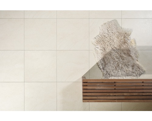 Helle Bodenfliesen mit Holzbank und Fellteppich