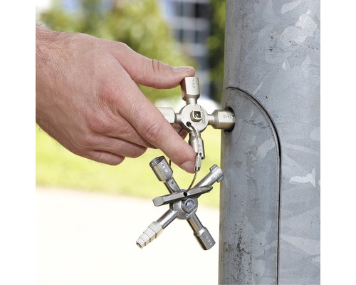 Ein Mann benutzt einen Universalschlüssel an einem Verteilerschrank.