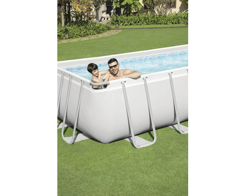 Piscine rectangulaire avec un homme et un enfant dans le jardin