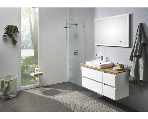 Salle de bains lumineuse avec lavabo, miroir, douche et accessoires de bain