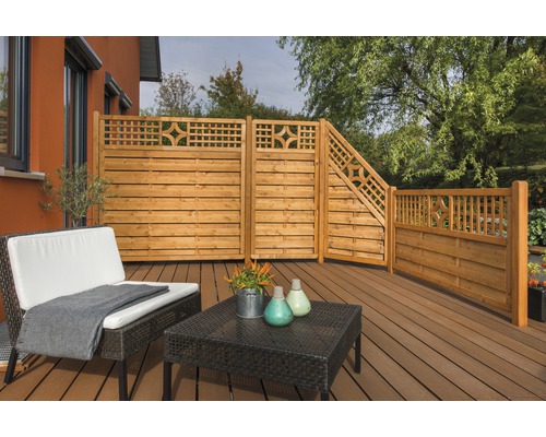 Holzzaun mit Sichtschutzelementen und Gartenmöbeln auf einer Terrasse