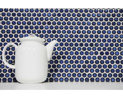 Mosaïque avec des pierres rondes bleues et une théière blanche