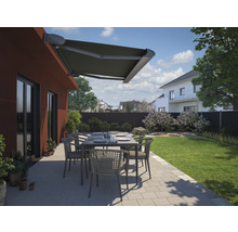 Terrasse mit Markise, Gartentisch und Stühlen vor einem Haus