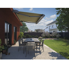 Terrasse mit Markise, Gartentisch und Stühlen vor einem Wohnhaus