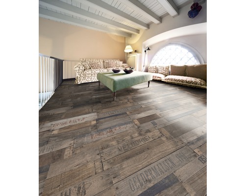 Wohnzimmer mit Holzboden in Dielenoptik mit Schriftzügen, Sofa und Tisch.